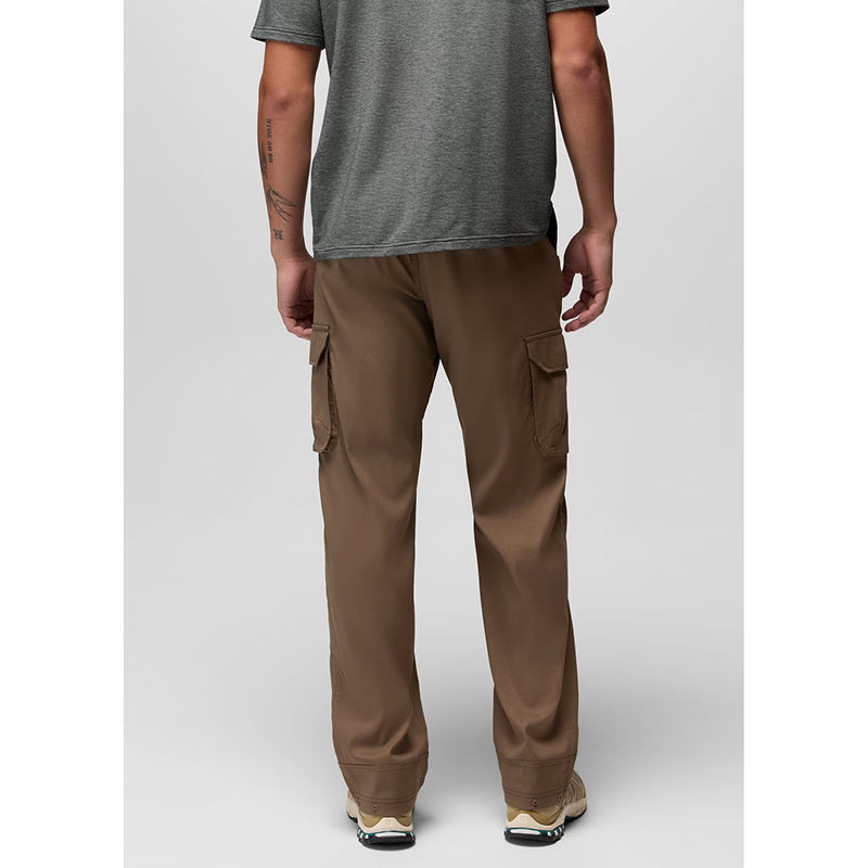 A man shown from the back wearing brown cargo pants, a heather gray t-shirt, and sneakers, photographed against a light gray studio background.