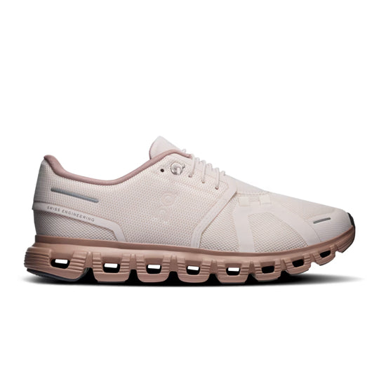 A single running shoe shown in a side profile on a clean white background. The shoe features a light beige mesh upper with subtle tonal overlays, matching beige laces, and a prominent dusty rose-pink cushioned sole with visible air pockets.