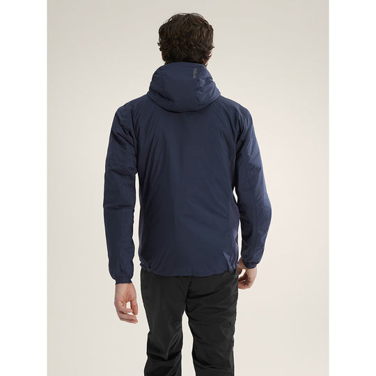Person wearing a blue jacket on a beige background