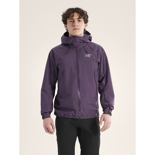 Person wearing a purple jacket with a brand logo on a beige background