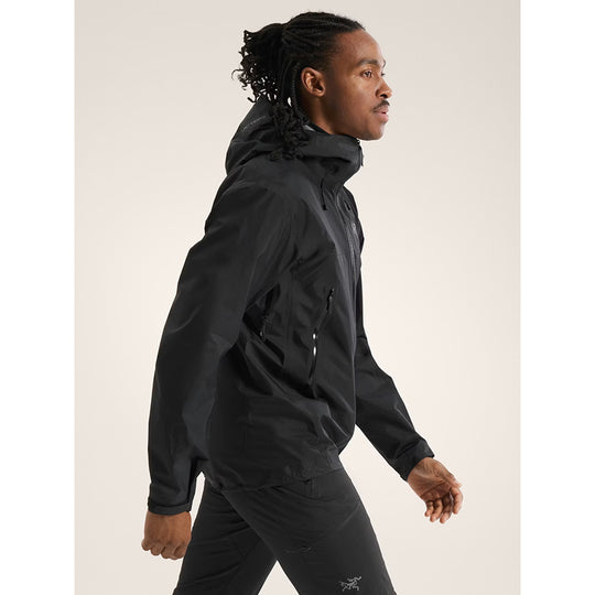 Person wearing a black jacket on a plain background