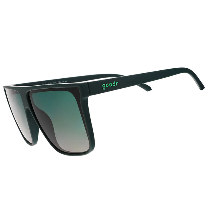 Sunglasses with green gradient lenses and black frame on a white background