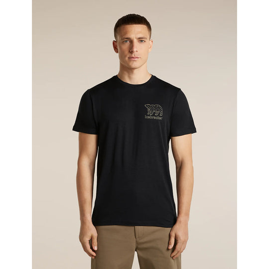 A man wearing a black short-sleeve crewneck t-shirt with a small dark embroidered polar bear graphic and the word &