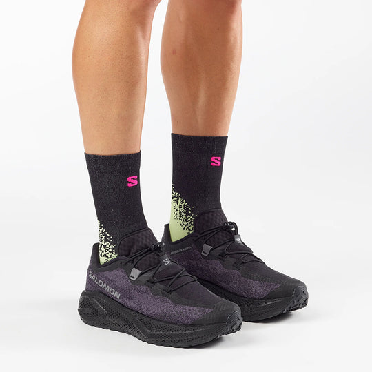 Black athletic shoes and socks with a visible brand logo on a white background