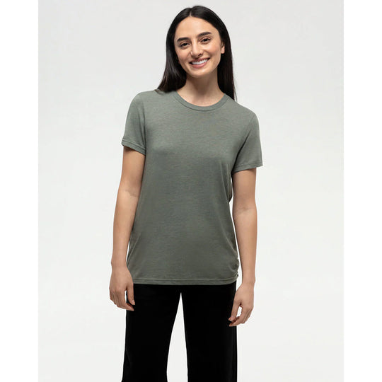 Woman wearing a green t-shirt and black pants on a white background