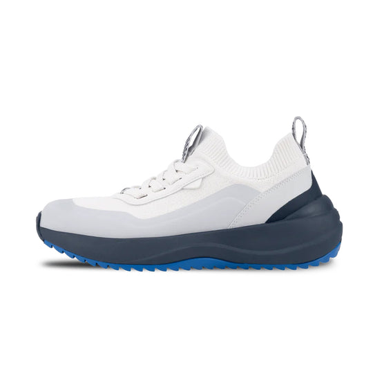 White sneaker with blue sole on a white background